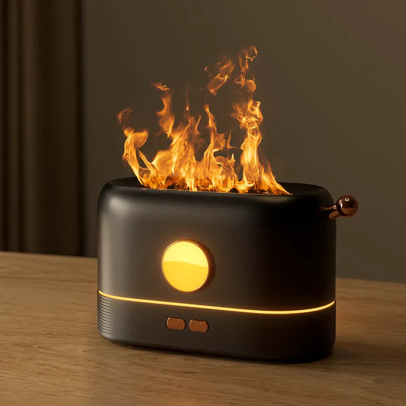 Black USB desktop humidifier with decorative orange flame effect and water tank on a wooden desk.