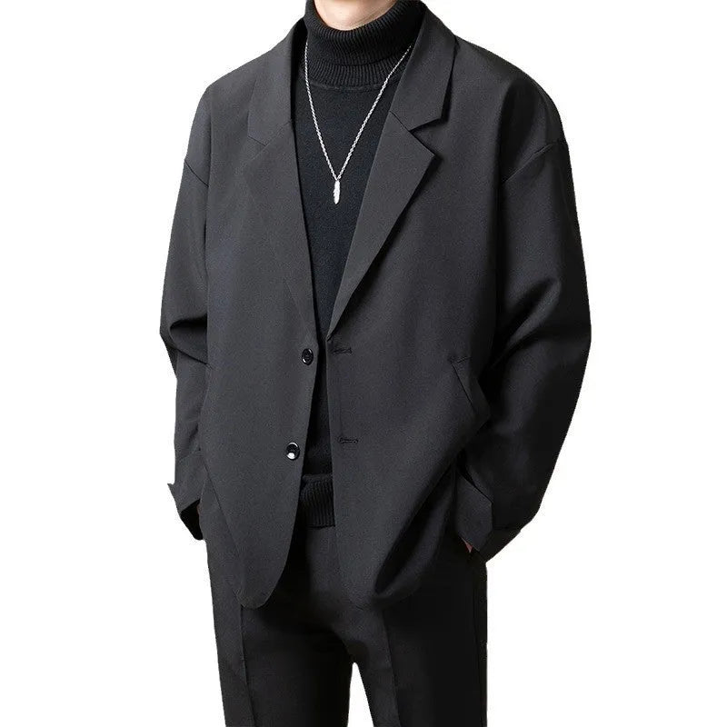 A man's loose fit suit jacket in a chemical fibre blend fabric, shown in one of four available colours.