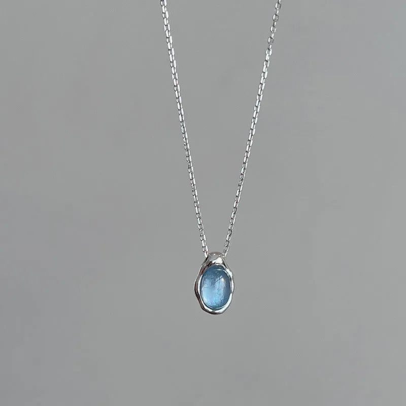 Navy blue water drop geometric pendant necklace with cross chain on white background