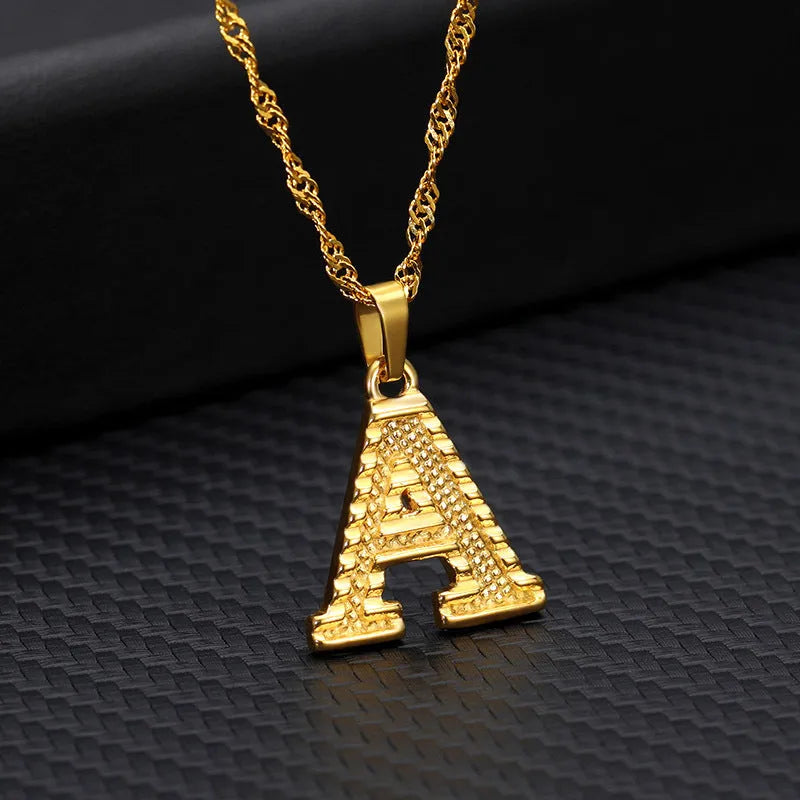 Gold-plated alloy initial pendant necklace with 42cm chain on white background