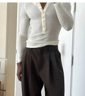 Man wearing cream-coloured ribbed long-sleeve henley top with four-button placket