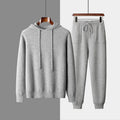 Men's light grey cashmere hooded sweatshirt and matching long pants set laid flat.