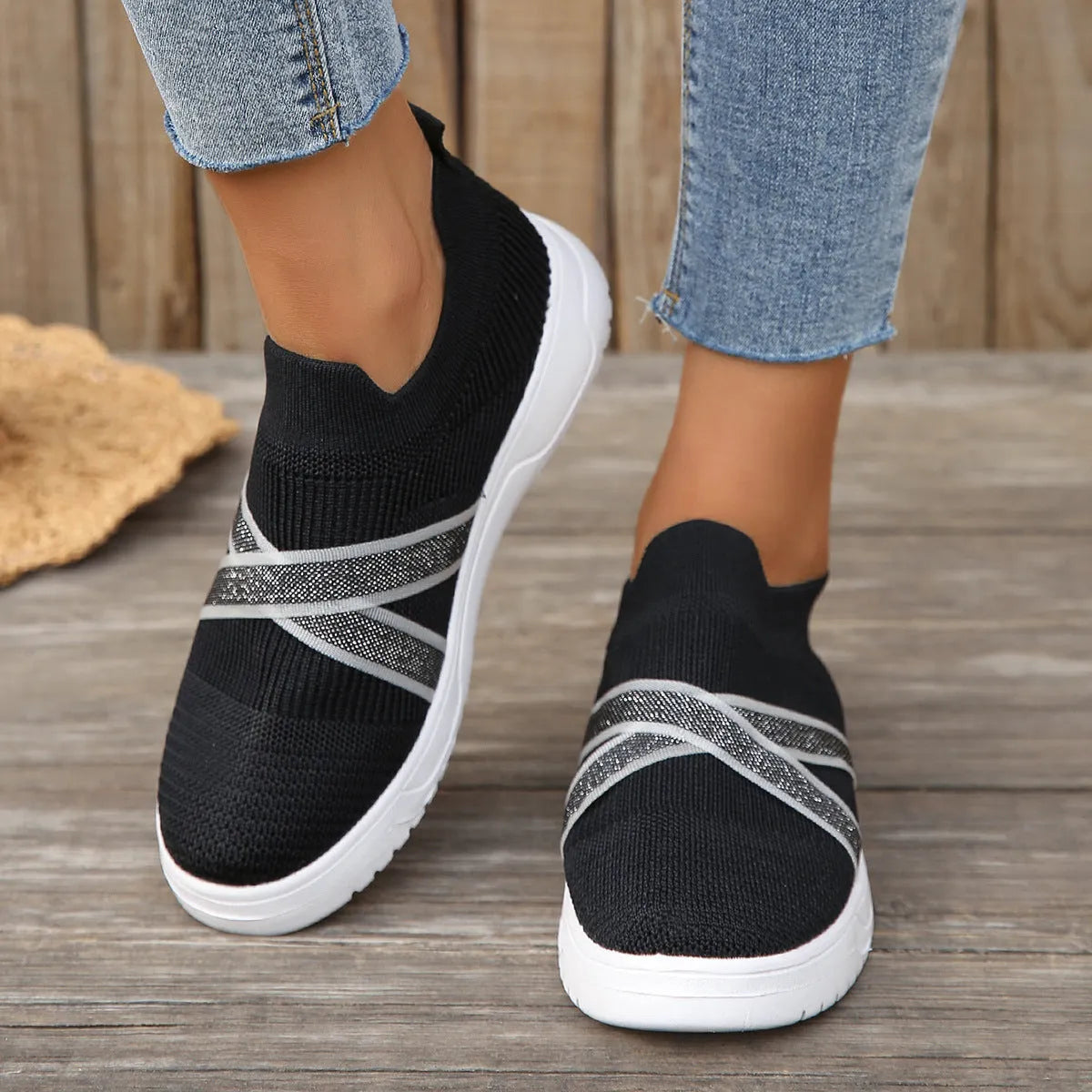 Black women's low-top flyknit mesh shoes with flat rubber sole and tassel detail.