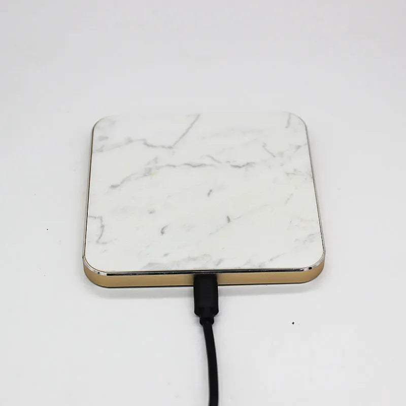 Real marble wireless charger on a desk with indicator light showing blue charging status