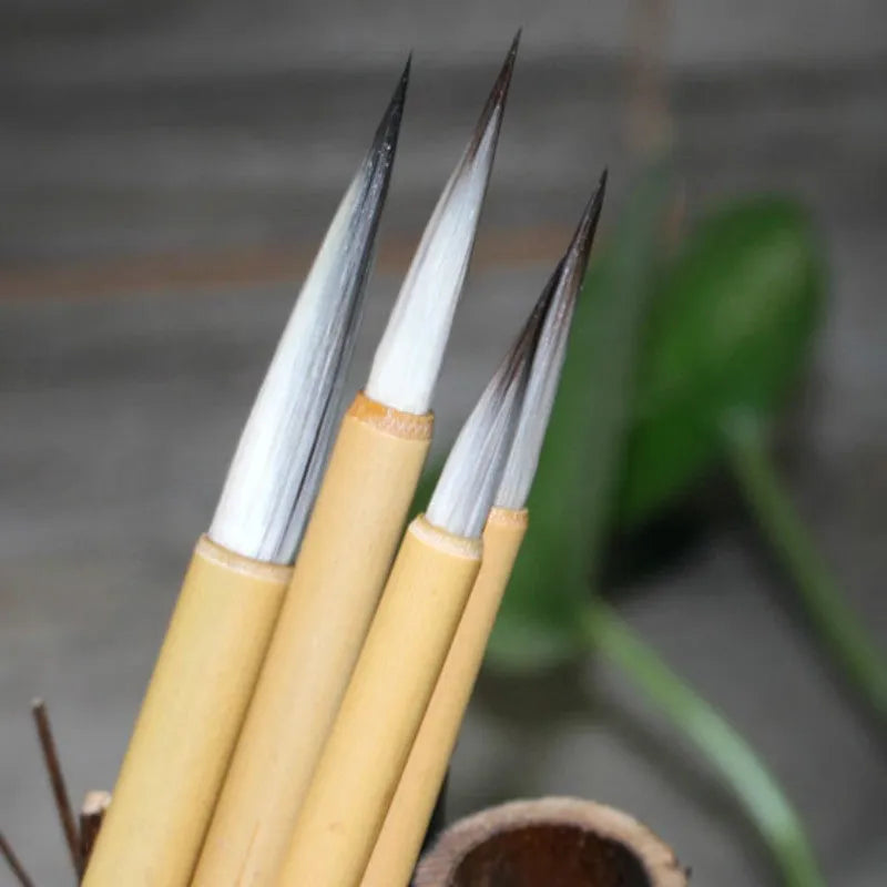 Set of four lower case writing brushes with thin gold body and mixed hair tip in pine branch colour for calligraphy