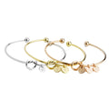 Personalised initial heart knot bracelet in gold finish with custom letter on a white background