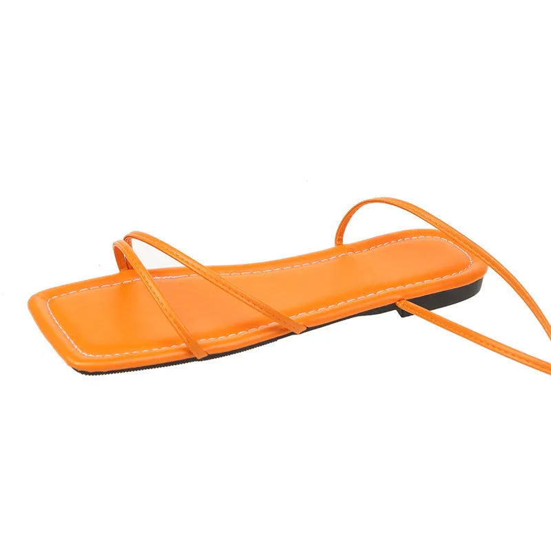 Women's white ankle strap flat sandals with lace-up front and square toe on a rubber sole.