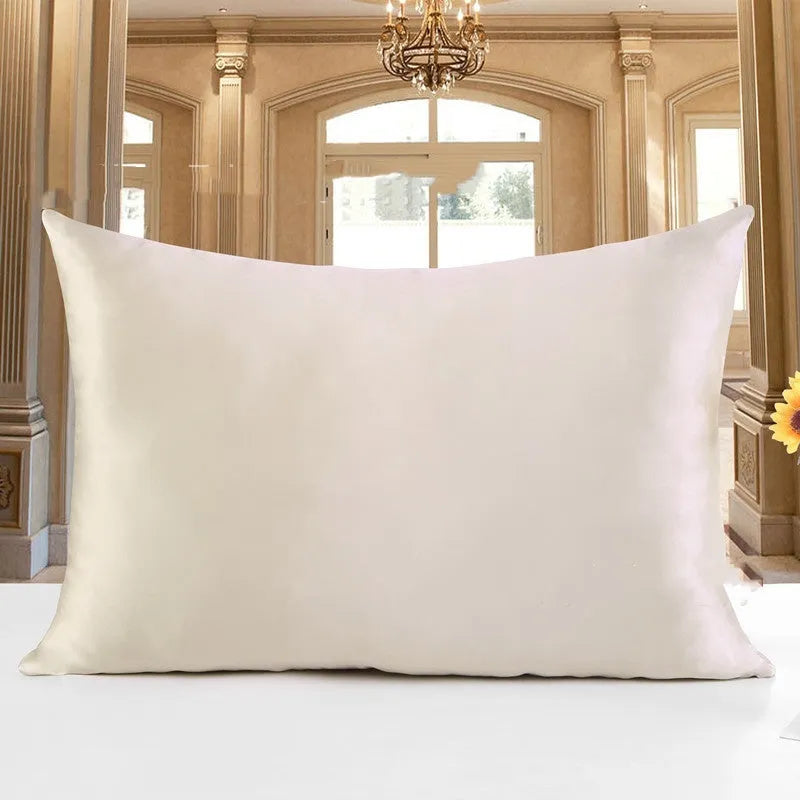 19 M double-sided silk pillowcase in apricot colour on a bed.