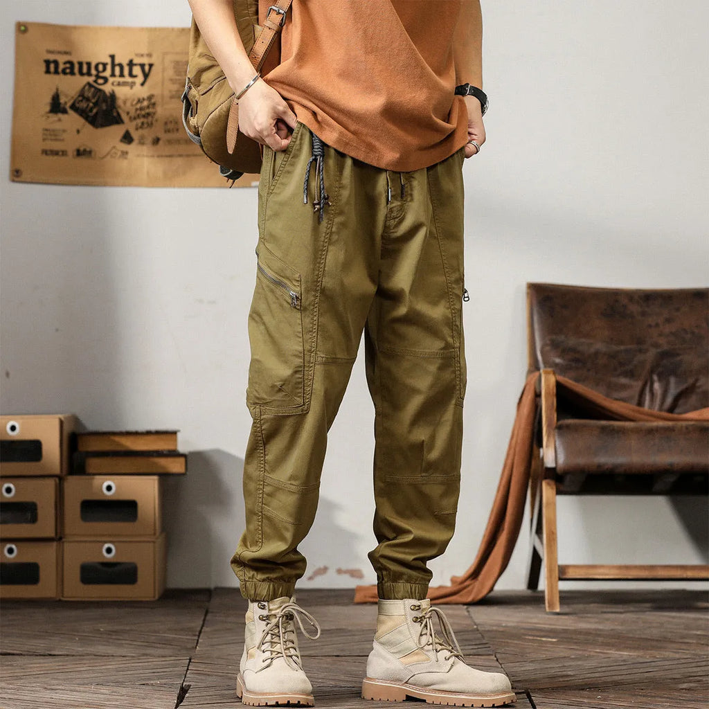 Men's loose fit cotton trousers with tapered ankle banded legs in khaki colour.