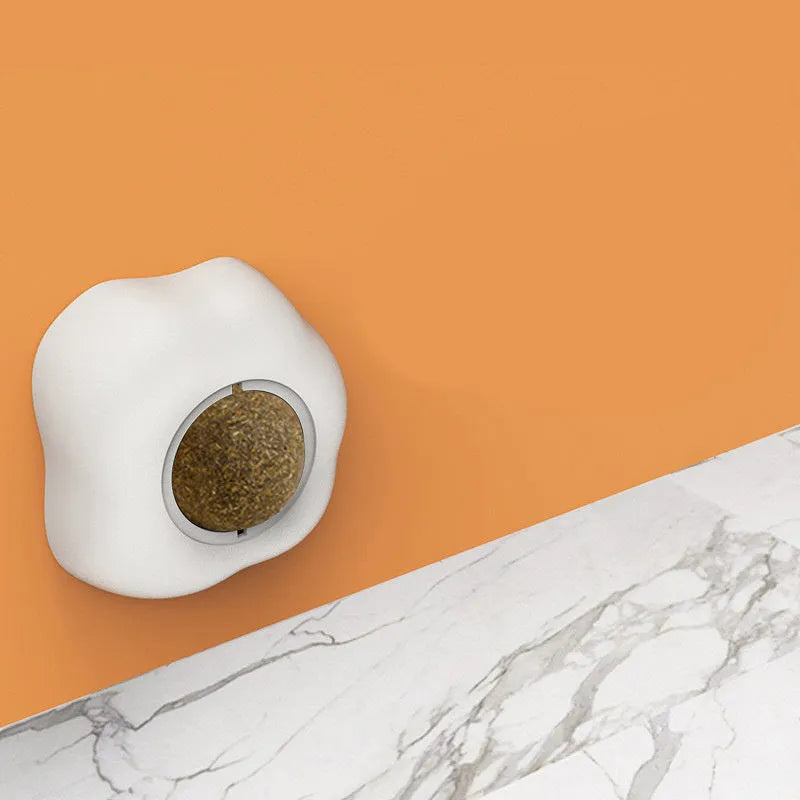 Interactive catnip ball toy with soft plush exterior mounted on wall surface