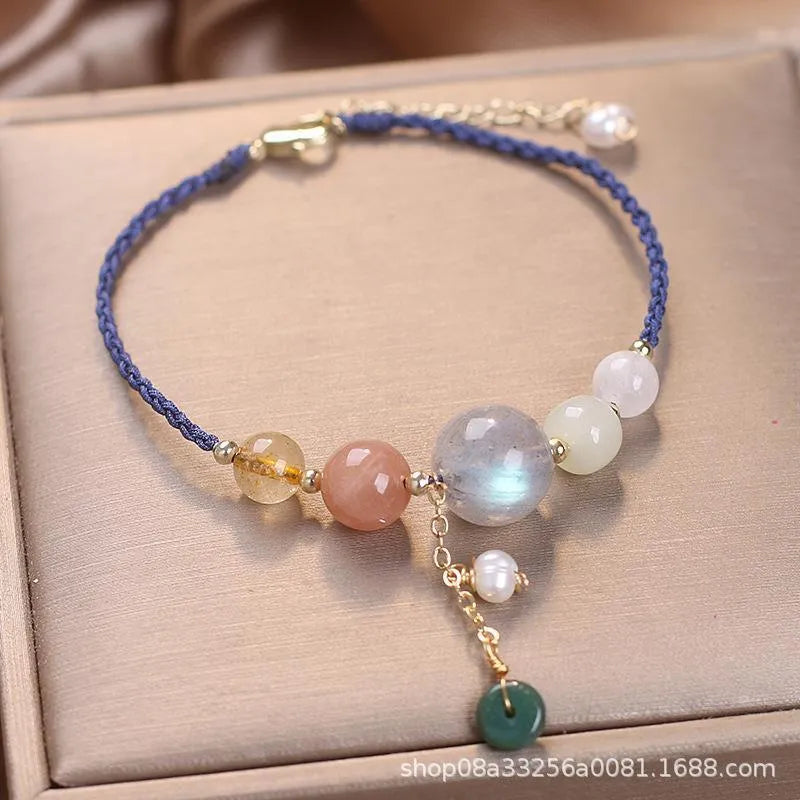 Women's hand-woven bracelet with peace buckle closure and crystal sequins in red, green, and blue colour options