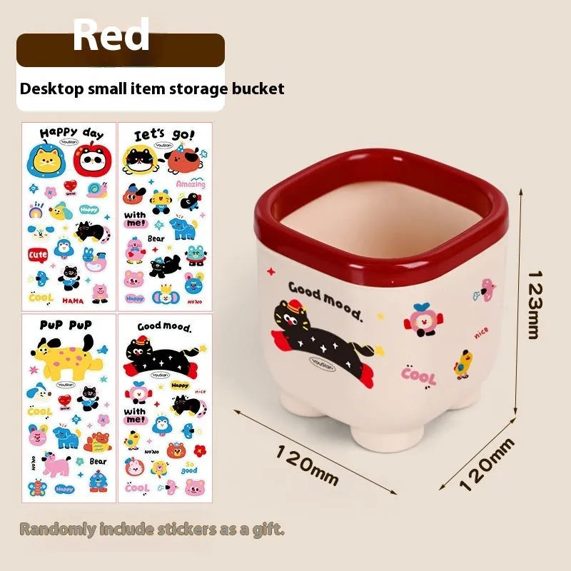 Cartoon-style red and brown plastic desktop storage box with grid compartments for organising pens and stationery.
