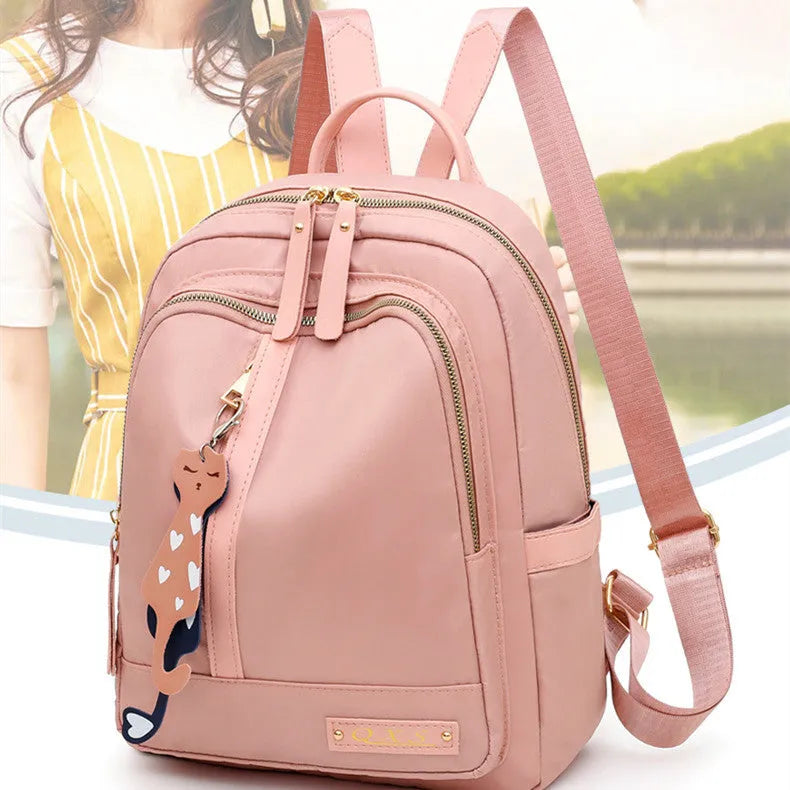 Women's casual nylon backpack in black or pink with square shape, showing external pocket and double straps.