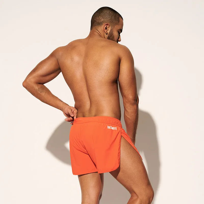 Men's loose fit beach shorts in fluorescent green, orange red, and black colours with micro-elastic polyester fabric