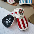 Four blue cloth dog shoes with zipper closures, shown on a small dog's paws.