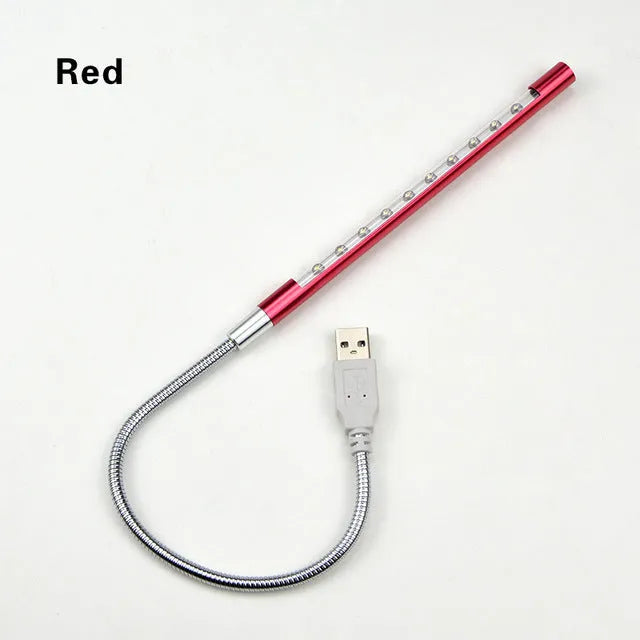 Black aluminium alloy spiral USB LED night light on a desk next to a laptop