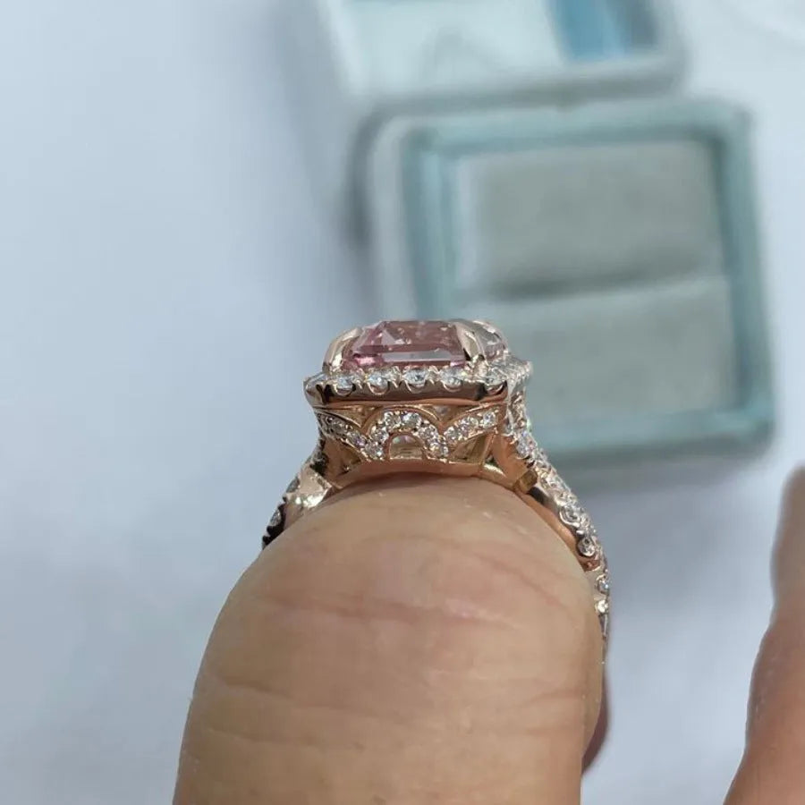 Rose gold geometric alloy ring on a plain background