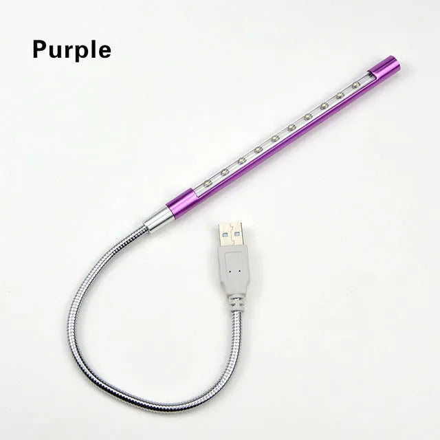 Black aluminium alloy spiral USB LED night light on a desk next to a laptop