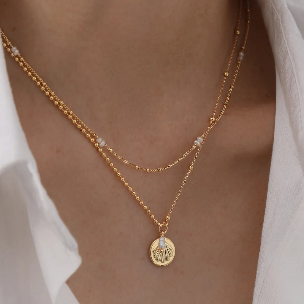 Natural pearl shell pendant necklace with adjustable copper chain on a neutral background