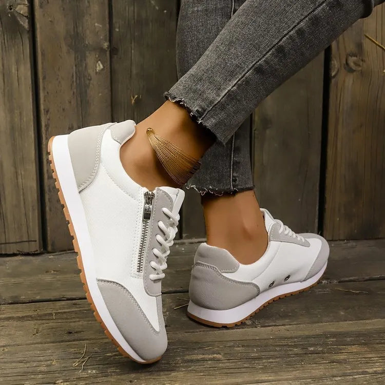 Women's grey flat-heeled shoes with artificial PU upper and rubber sole on a plain background.