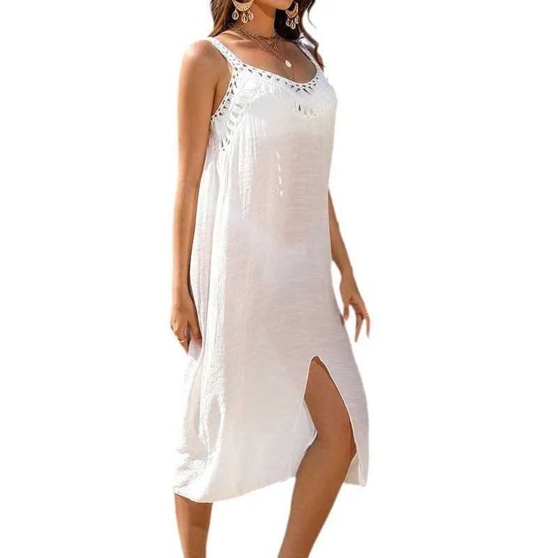 White crochet beach dress with hollow weaving and a bottom slit, shown on a hanger
