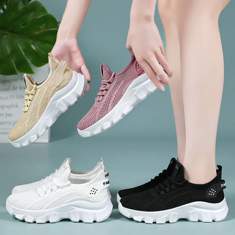 Women's white Flyknit running sneakers with round toe, flat heel, and thick PVC sole on a light background.