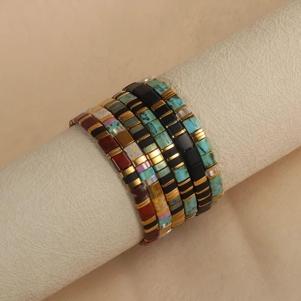 Geometric pull bead bracelet in milky white glass beads on a wrist.