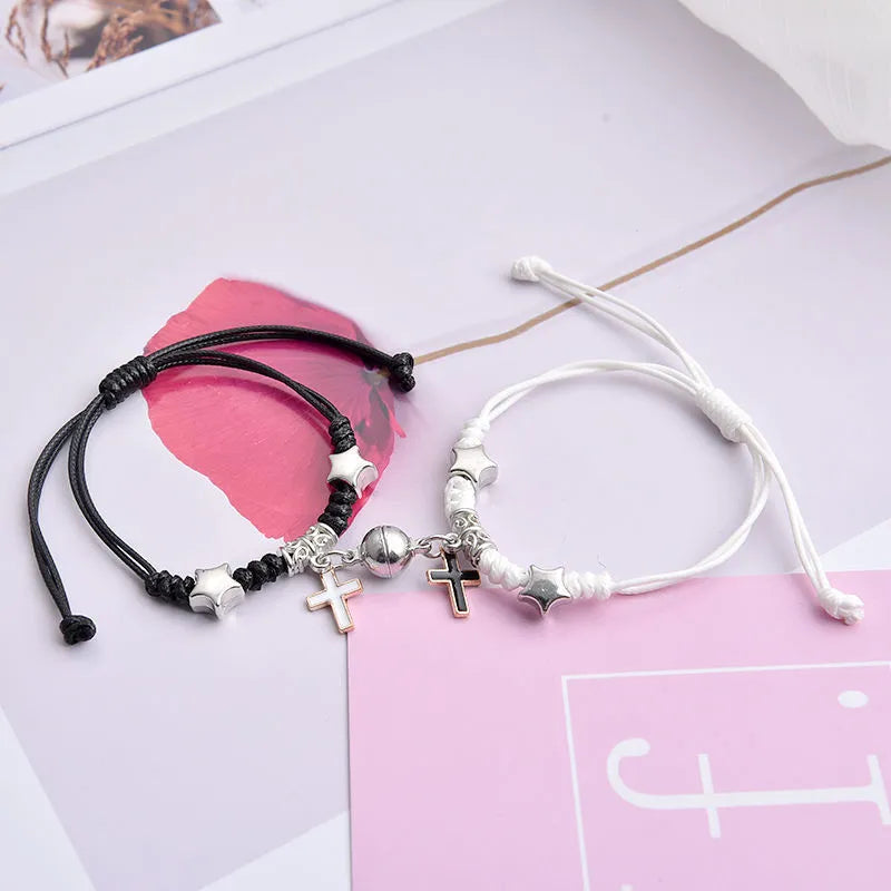Pair of magnetic suction bracelets with alloy charms in various love and friendship themed designs on a wrist.