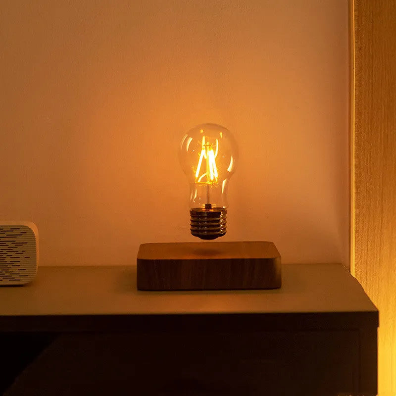 Creative minimal self-rotating maglev bulb with ABS base and warm yellow light on a desk