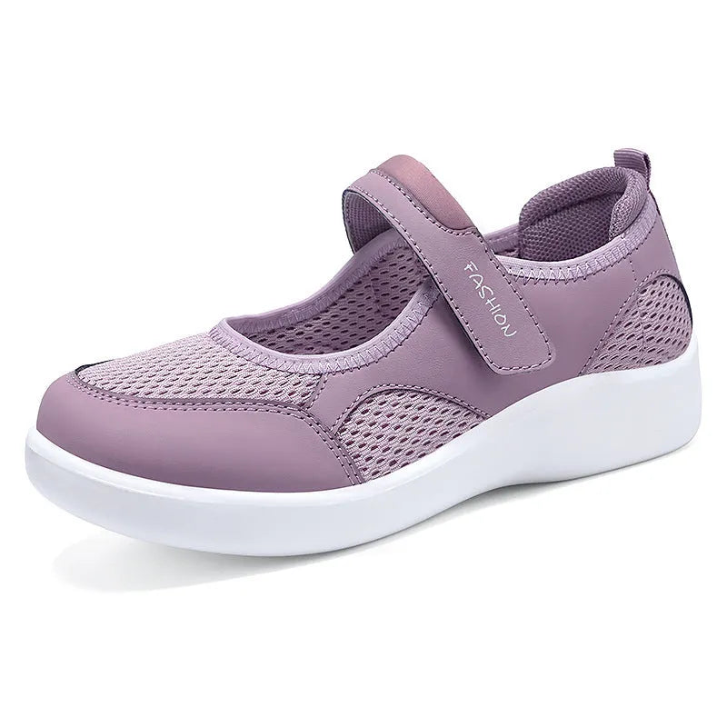 Women's low-top grey mesh sneakers with Velcro straps on a flat polyurethane sole.