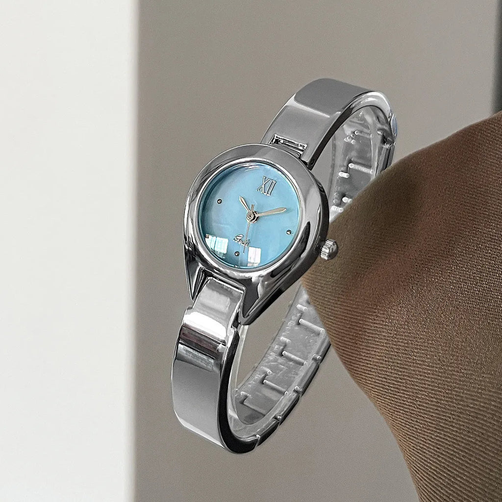 Women's quartz watch with 30mm white shell dial, silver hands, and white strap on display
