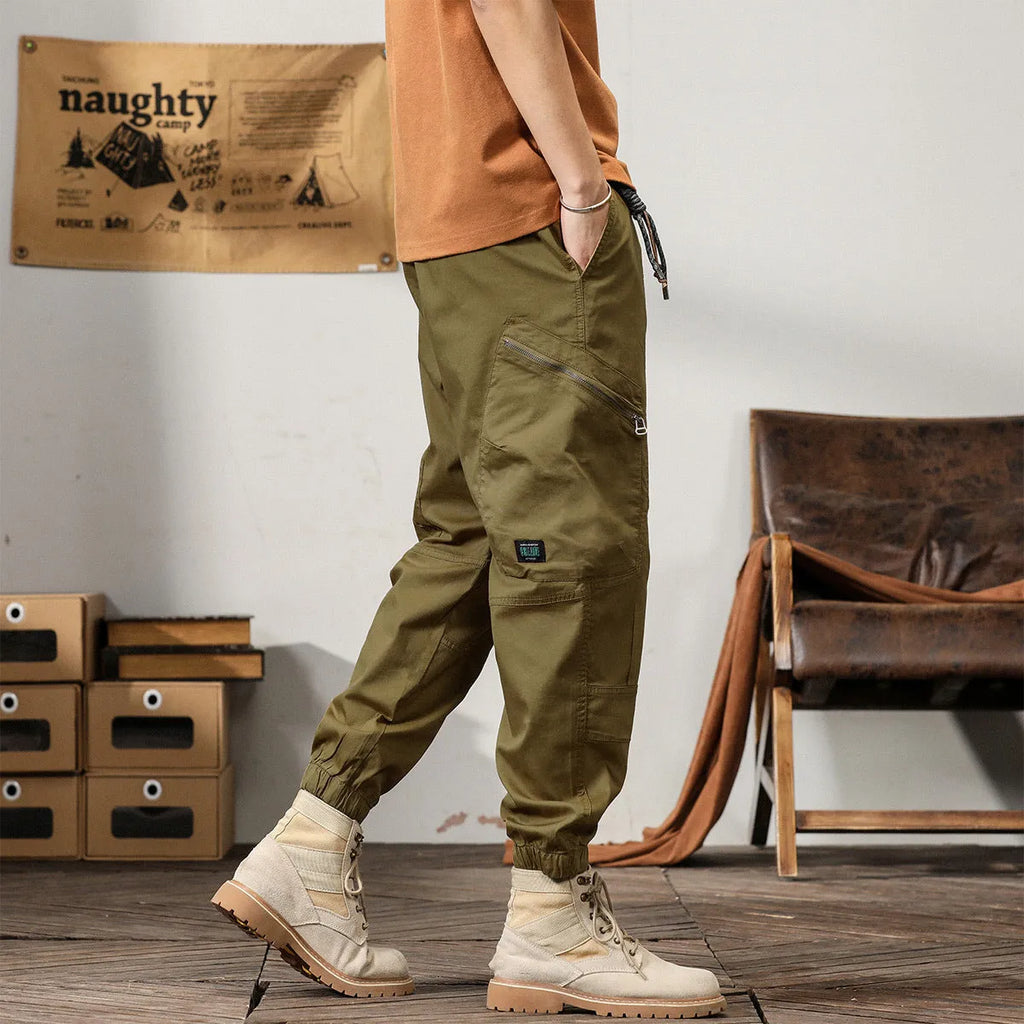 Men's loose fit cotton trousers with tapered ankle banded legs in khaki colour.