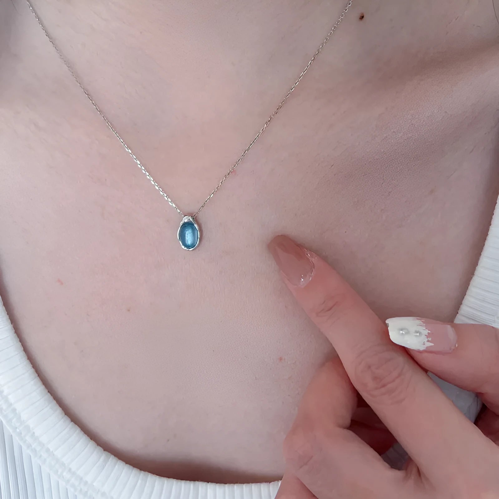 Navy blue water drop geometric pendant necklace with cross chain on white background