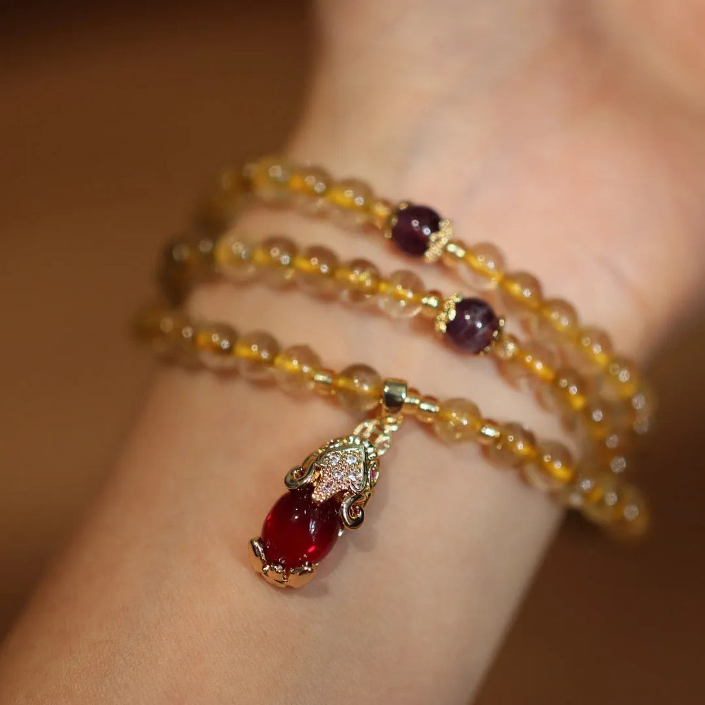 Handmade gold and ruby quartz Chinese bracelet with three circles and hanging chopstick detailing