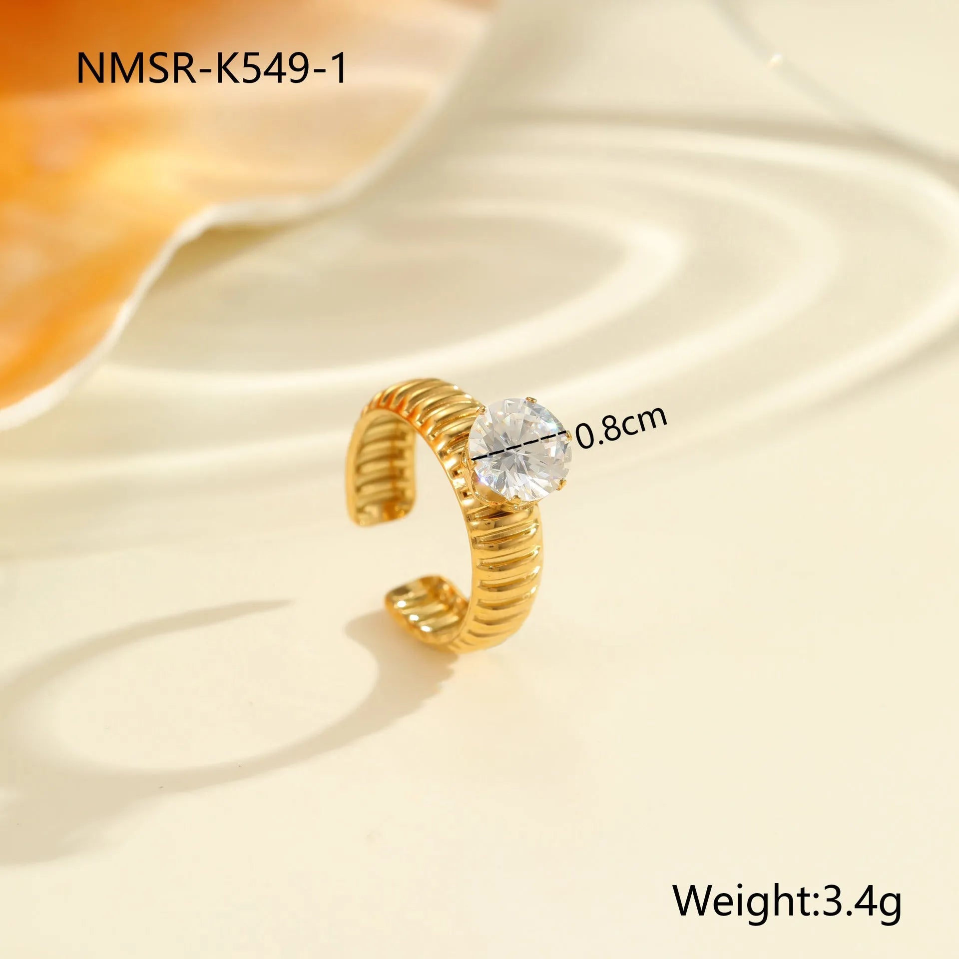 Gold-coloured adjustable stainless steel ring with zircon geometric shapes on white background.