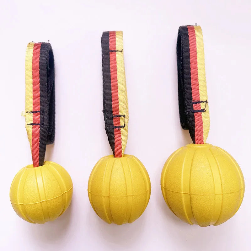 Yellow and camouflage coloured EVA foam floating dog ball with string attached for fetch and water training.