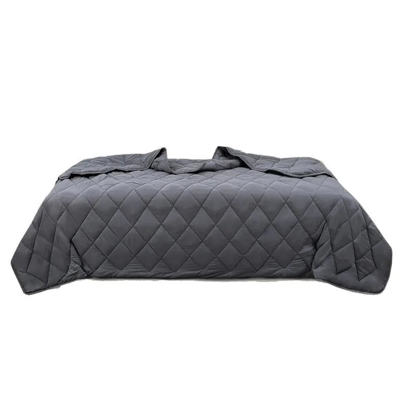 Polyester gravity blanket in solid light grey on bed, 152x203cm size, 12 lb weight option