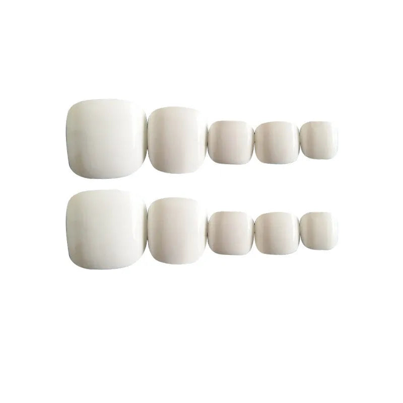 White press-on fake nails with a starry sky pattern, shown alongside a bottle of nail glue.