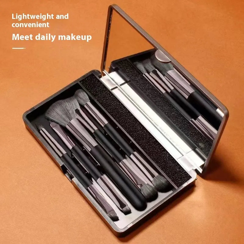 Makeup brush set in case with mirror showing 4 or 5 artificial fibre brushes in silver, gold or sparrow design