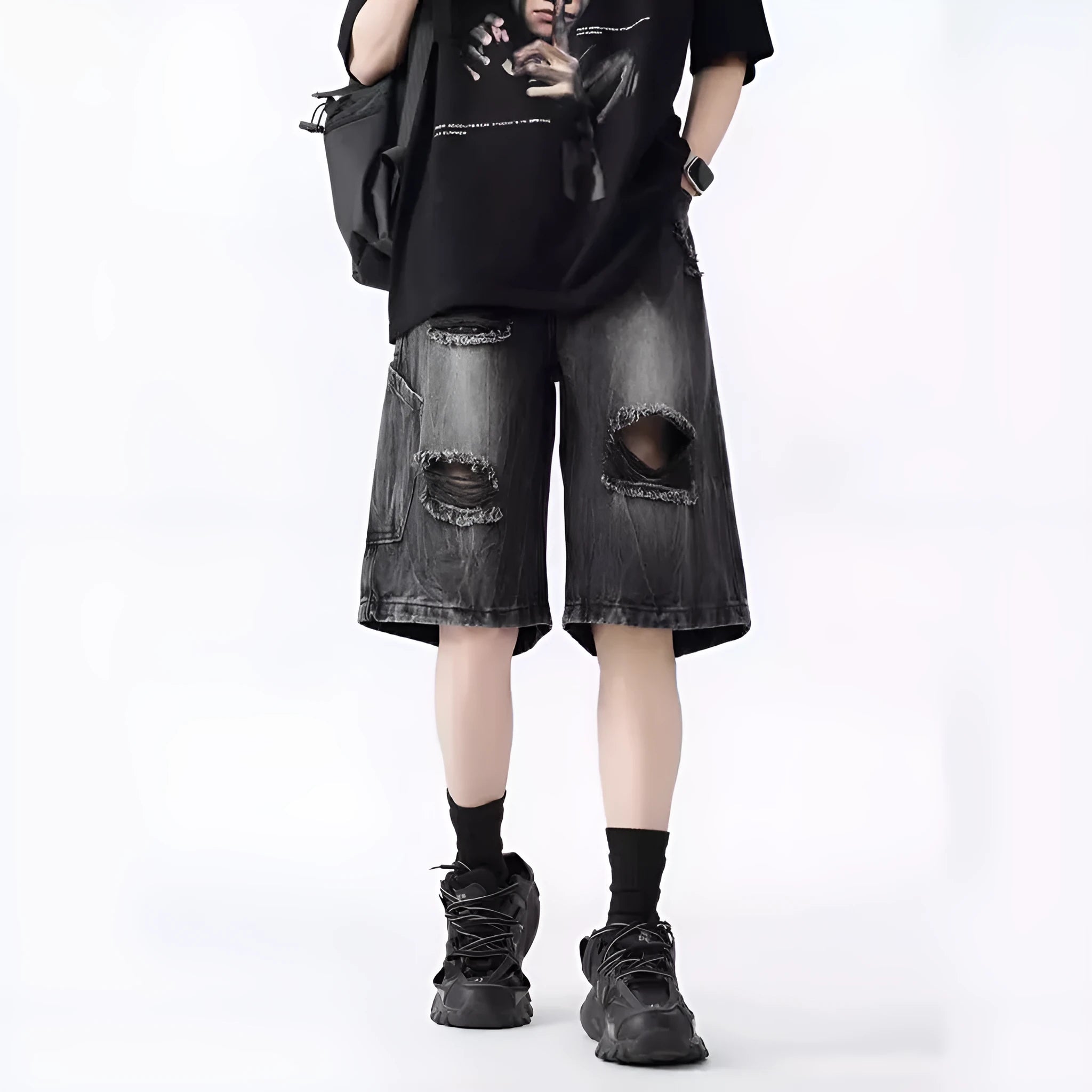 Man wearing loose blue ripped denim shorts with a vintage wash and distressed details.