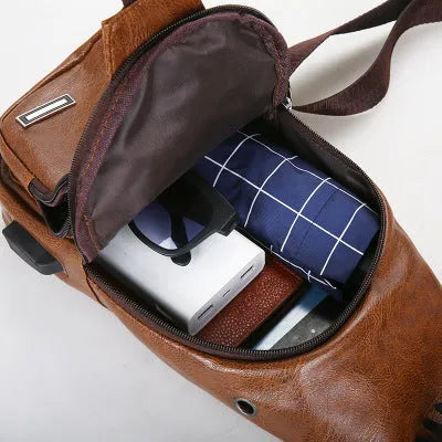 USB charging chest bag in black PU leather with embossed pattern showing front zipper and USB port