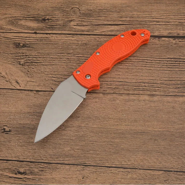 Portable folding fruit knife with black handle and silver 9CR13MOV blade on a wooden surface