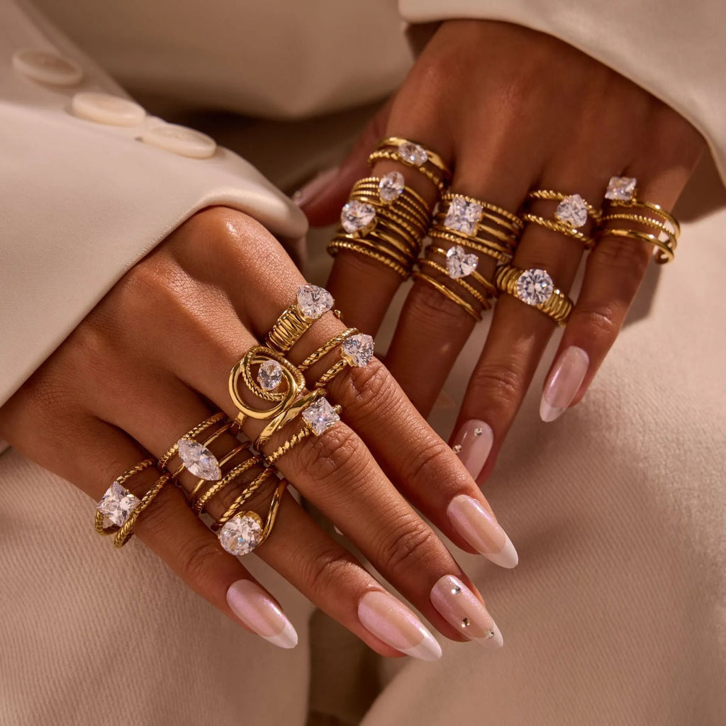 Gold-coloured adjustable stainless steel ring with zircon geometric shapes on white background.
