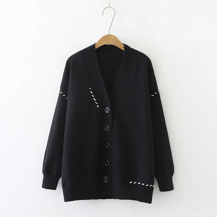 Women's loose fit black knitted cardigan coat with long sleeves on a hanger.