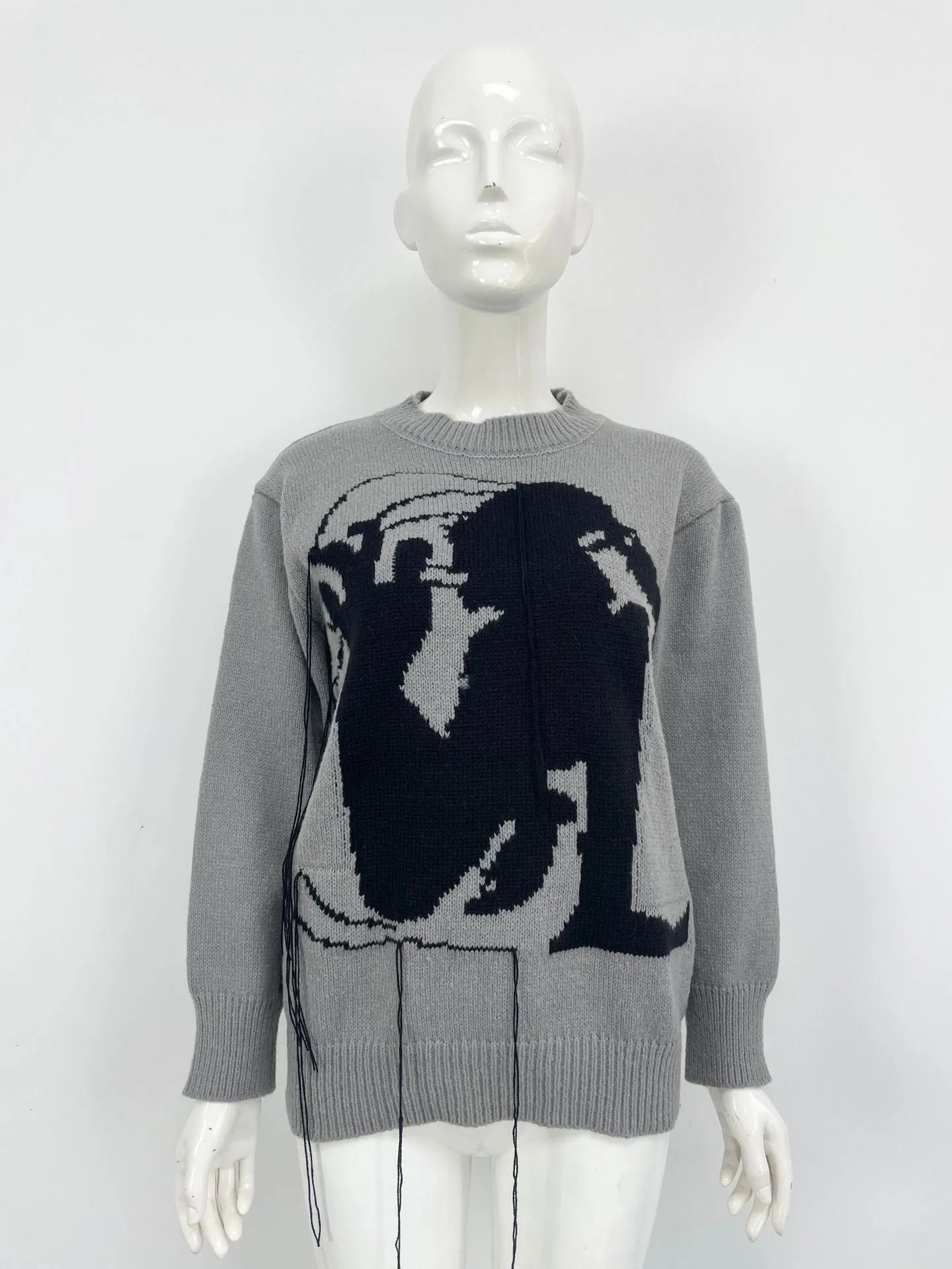 Grey women's loose alpaca wool sweater with tassel detail and abstract pattern, round neck.