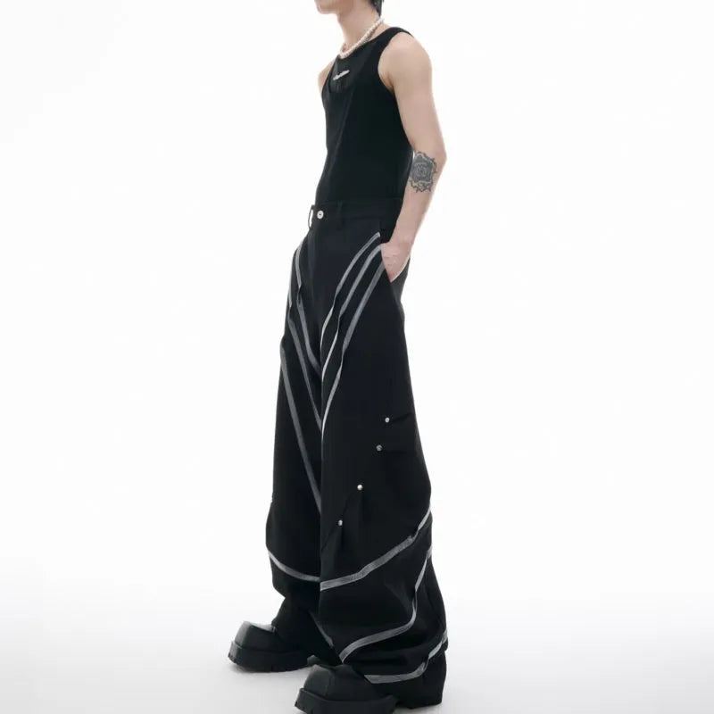 Men's black trousers with three-dimensional cut and silver metal rivet pleat detailing.