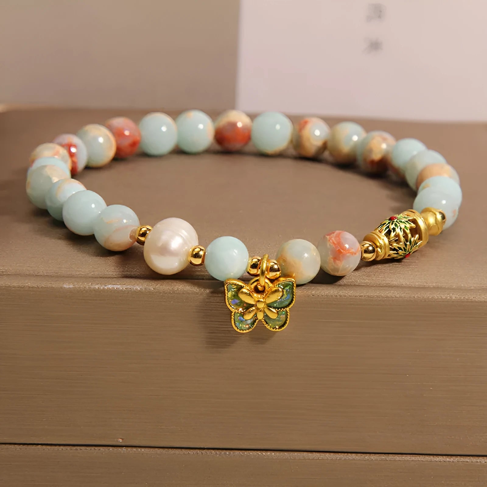 Shoushan stone and freshwater pearl bracelet with blue butterfly pendant on display