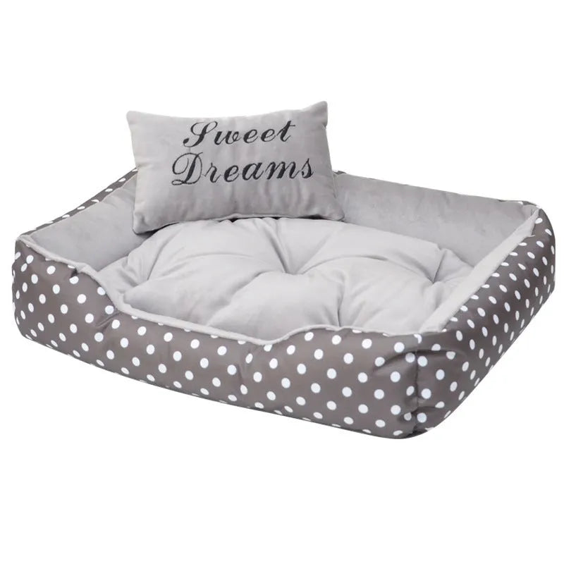 Polka dot print dog bed with matching embroidered cushion in grey, shown in a home setting.