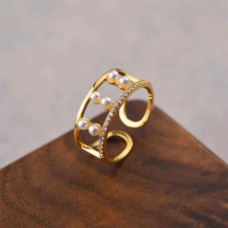 Gold tone geometric open back fashion ring on a hand, showing its adjustable design.