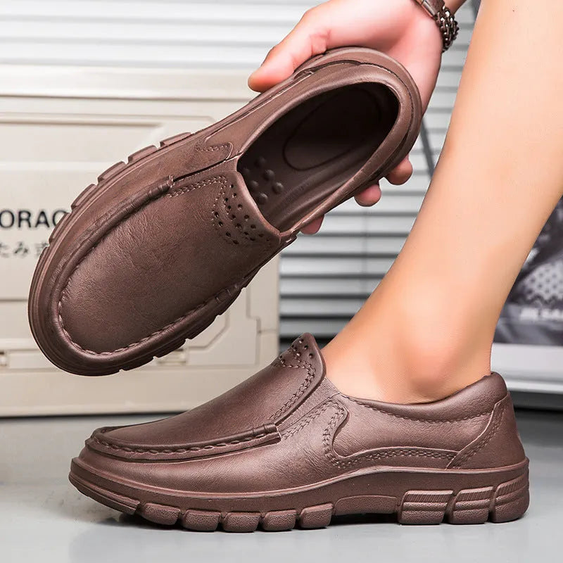 Men's black slip-on work shoes with a mid-top waterproof artificial leather upper and platform sole.